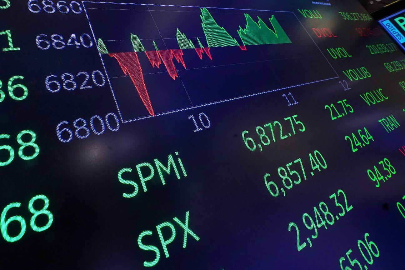 A chart above the trading floor of the New York Stock Exchange displays an intraday number for the SPY, tracking the S&P 500, Friday, Feb. 13, 2026. (AP Photo/Richard Drew)