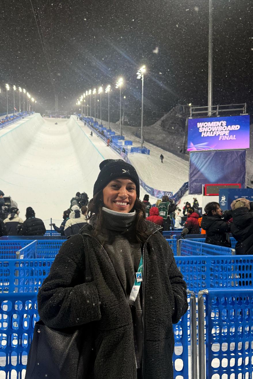 This photo provided by TOGETHXR shows Kenz McGuire, senior social media manager at women's sports media and commerce company TOGETHXR, covering the Milan Cortina Olympics women's snowboard halfpipe final on Feb. 12, 2026, in Livigno, Italy. (Kenz McGuire/TOGETHXR via AP)