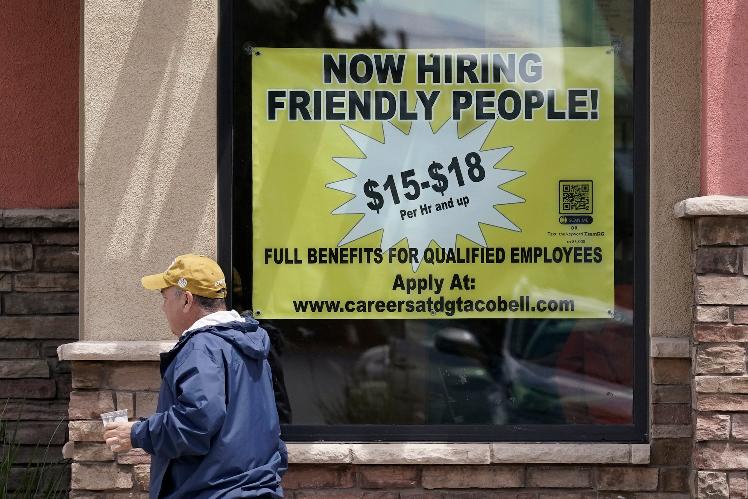 FILE - Starting wages are advertised on a sign in the window of a Taco Bell in Sacramento, Calif., Monday, May 9, 2022. A wave of retirements, a drop in legal immigration, and hundreds of thousands of COVID-19 deaths have left the U.S. with a smaller workforce than when the pandemic began two and half years ago, a change that could bolster wage growth and inflation and force the Federal Reserve to keep interest rates higher for longer. (AP Photo/Rich Pedroncelli)