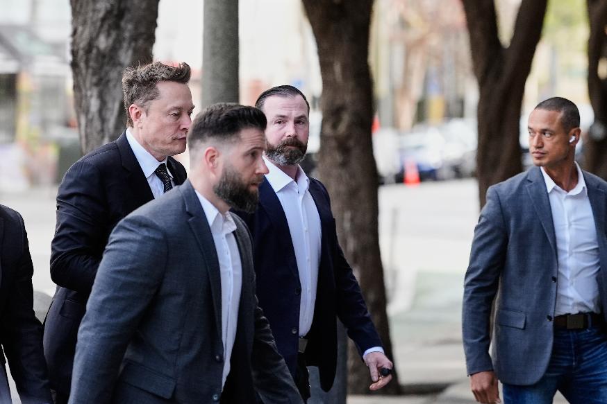 Elon Musk, left, arrives for a Twitter shareholder trial at the U.S. District Court for the Northern District of California, Wednesday, March 4, 2026, in San Francisco. (AP Photo/Godofredo A. Vásquez)