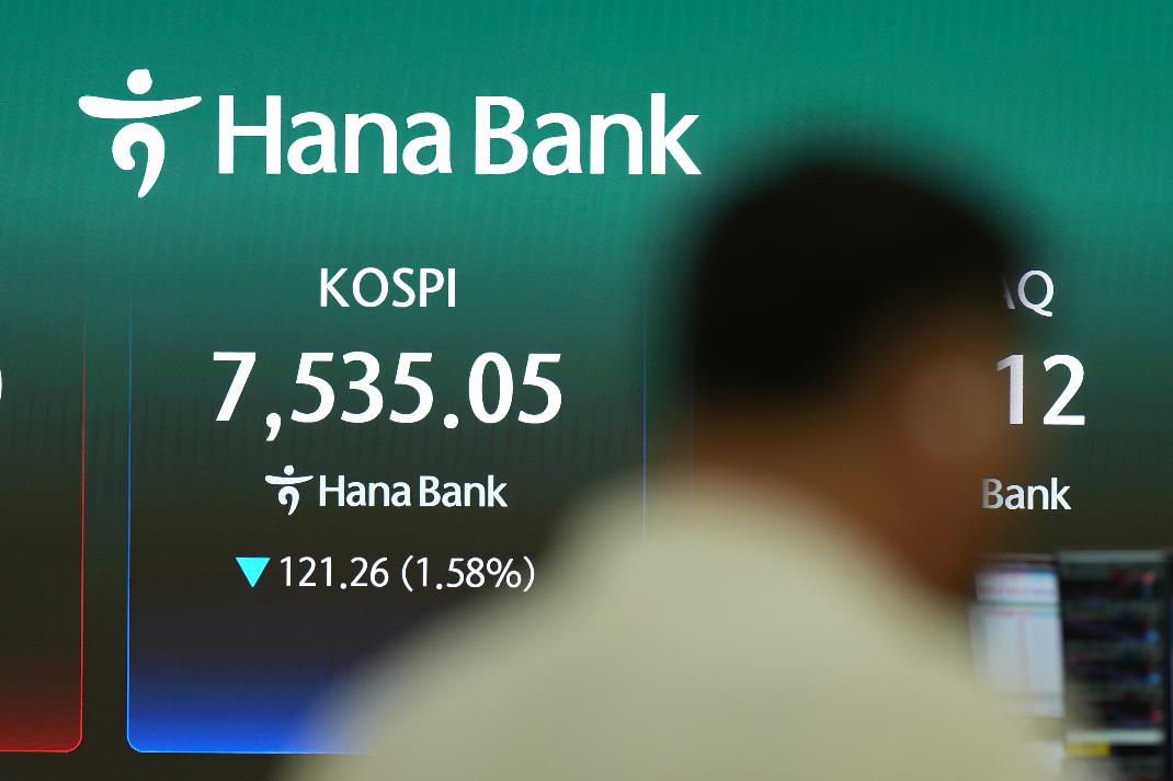 A member of media stands near the screen showing the Korea Composite Stock Price Index (KOSPI) at a dealing room of Hana Bank in Seoul, South Korea, Wednesday, July 8, 2026. (AP Photo/Lee Jin-man)