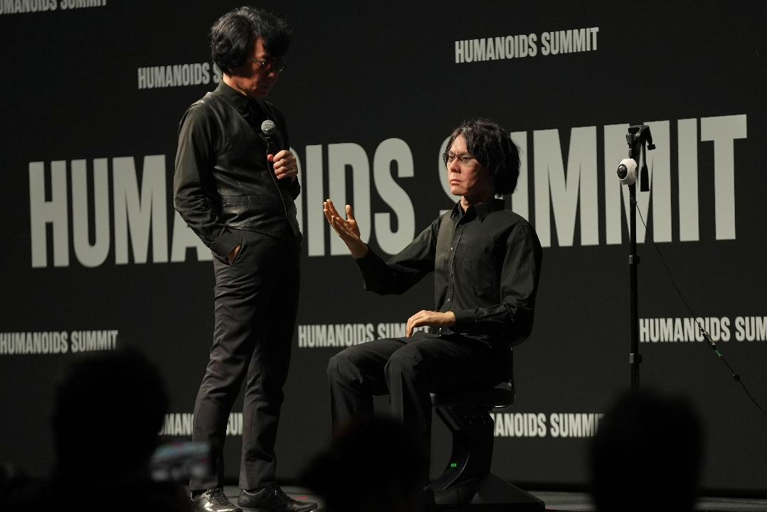 Professor Hiroshi Ishiguro of Osaka University talks to android robot Geminoid at the Humanoids Summit 2026 in Tokyo, Thursday, May 28, 2026. (AP Photo/Ayaka McGill)