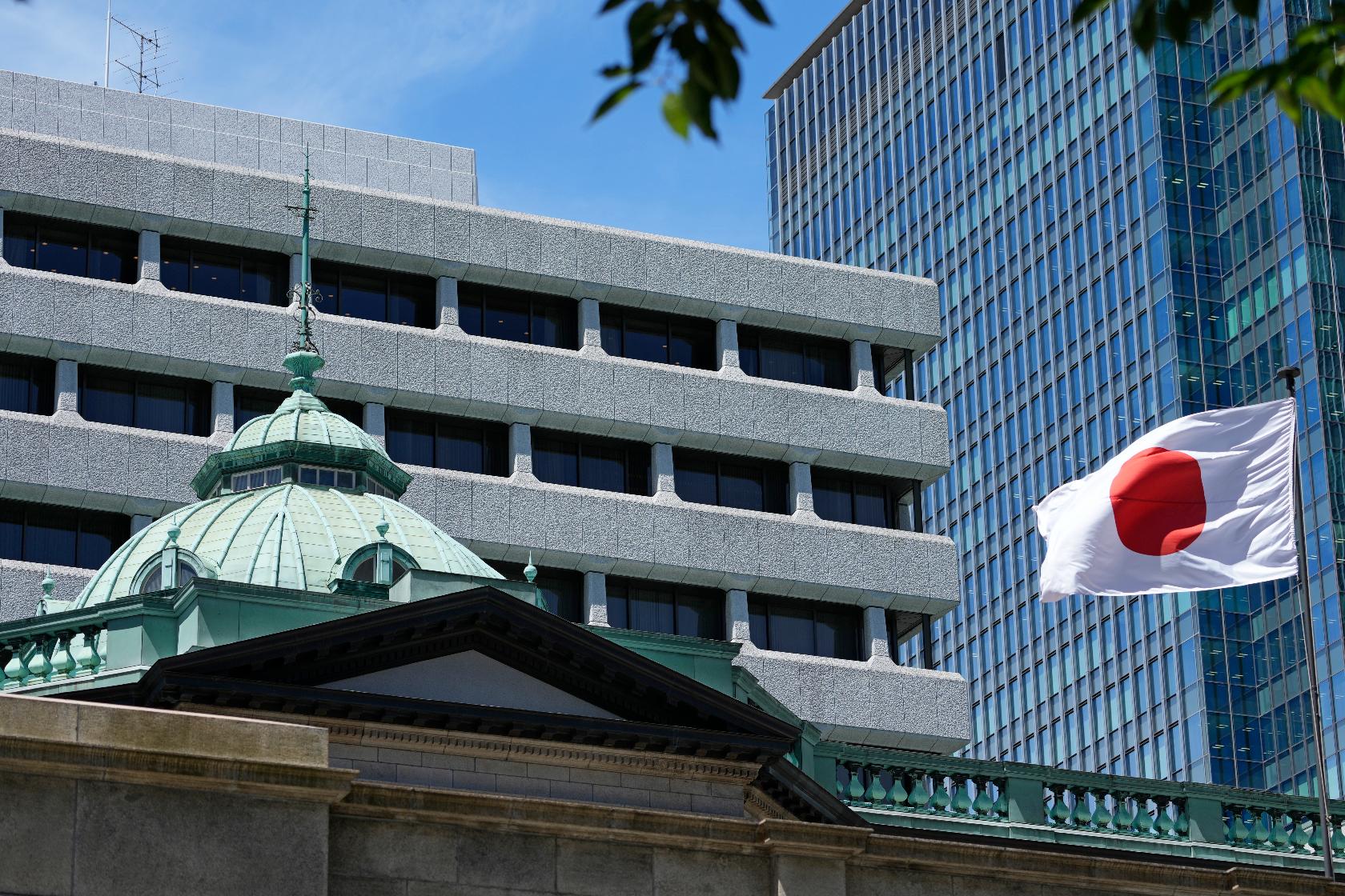 FILE - A Japanese flag flutters at the Bank of Japan headquarters in Tokyo, Thursday, July 29, 2022. A key Japanese central bank report said Monday, April 1, 2024, that sentiment among big manufacturers has sagged but that optimism is at a three-decade high among large business outside the manufacturing sector. (AP Photo/Shuji Kajiyama, File)