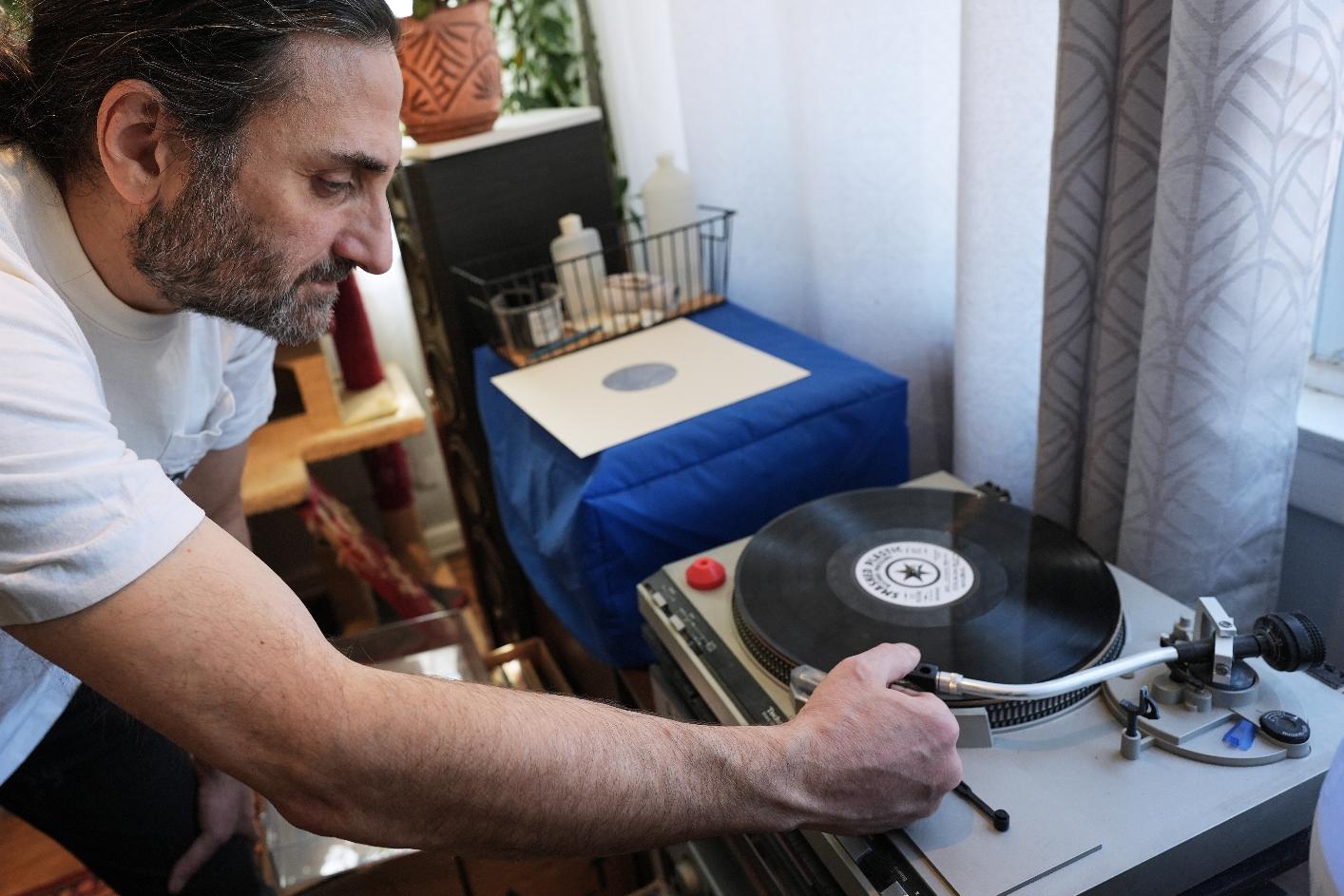 Aadam Jacobs plays a LP (long play) record at his home in Chicago, Thursday, March 19, 2026. (AP Photo/Nam Y. Huh)
