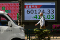 A person walks in front of an electronic stock board showing Japan's Nikkei index at a securities firm, Tuesday, April 28, 2026, in Tokyo. (AP Photo/Eugene Hoshiko)