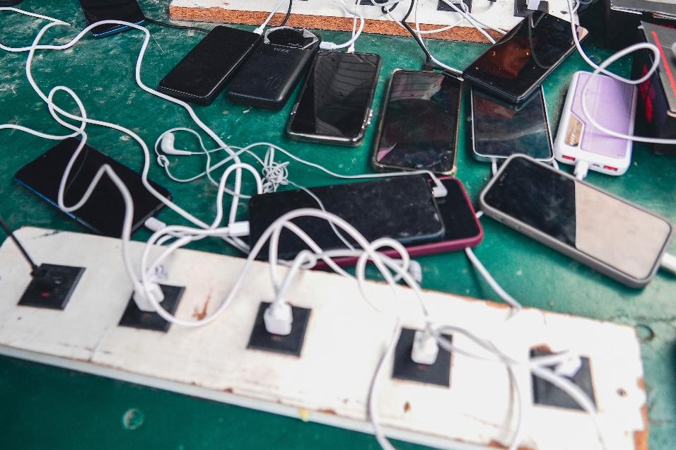 FILE - Phones are kept for charging at a Doctors Without Borders informal camp in Mardyck, northern France, Wednesday, July 2, 2025. (AP Photo/Nicolas Garriga, File)