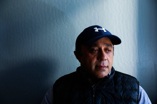 Ali Badr, a resident of Oakland and Egyptian immigrant, poses for a photo at his attorney's office in Oakland, Calif., on Dec. 16, 2021. Badr, a gig driver who was badly mauled by a police dog is suing the San Francisco Bay Area city of San Ramon, alleging use of excessive force and violation of civil rights when police stopped him in December 2020 for missing rental car payments. Badr drove for Uber and Lyft and started delivering food for DoorDash when the pandemic hit. (Yalonda M. James/San Francisco Chronicle via AP)