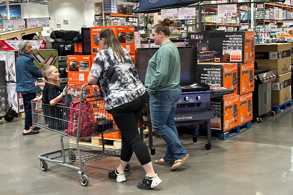 FILE - Shoppers move amid items for outdoor cooking on display in a Costco warehouse Thursday, March 12, 2026, in east Denver. (AP Photo/David Zalubowski, File)