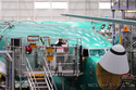 An employee works on a computer next to a Boeing 737 MAX airplane being built on the final assembly line during a media tour at Boeing's factory Wednesday, April 15, 2026, in Renton, Wash. (AP Photo/Lindsey Wasson)