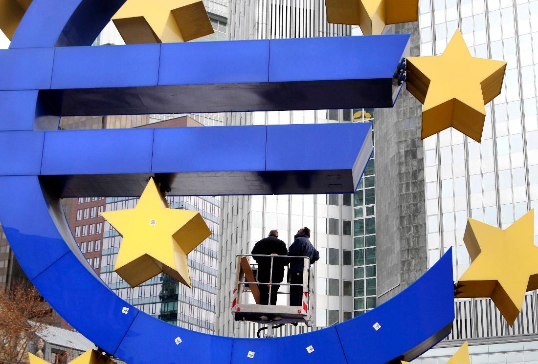 FILE -Workers change tube lights of the Euro sculpture in front of the European Central Bank in Frankfurt, Germany, Dec.6, 2011. (AP Photo/Michael Probst, File)