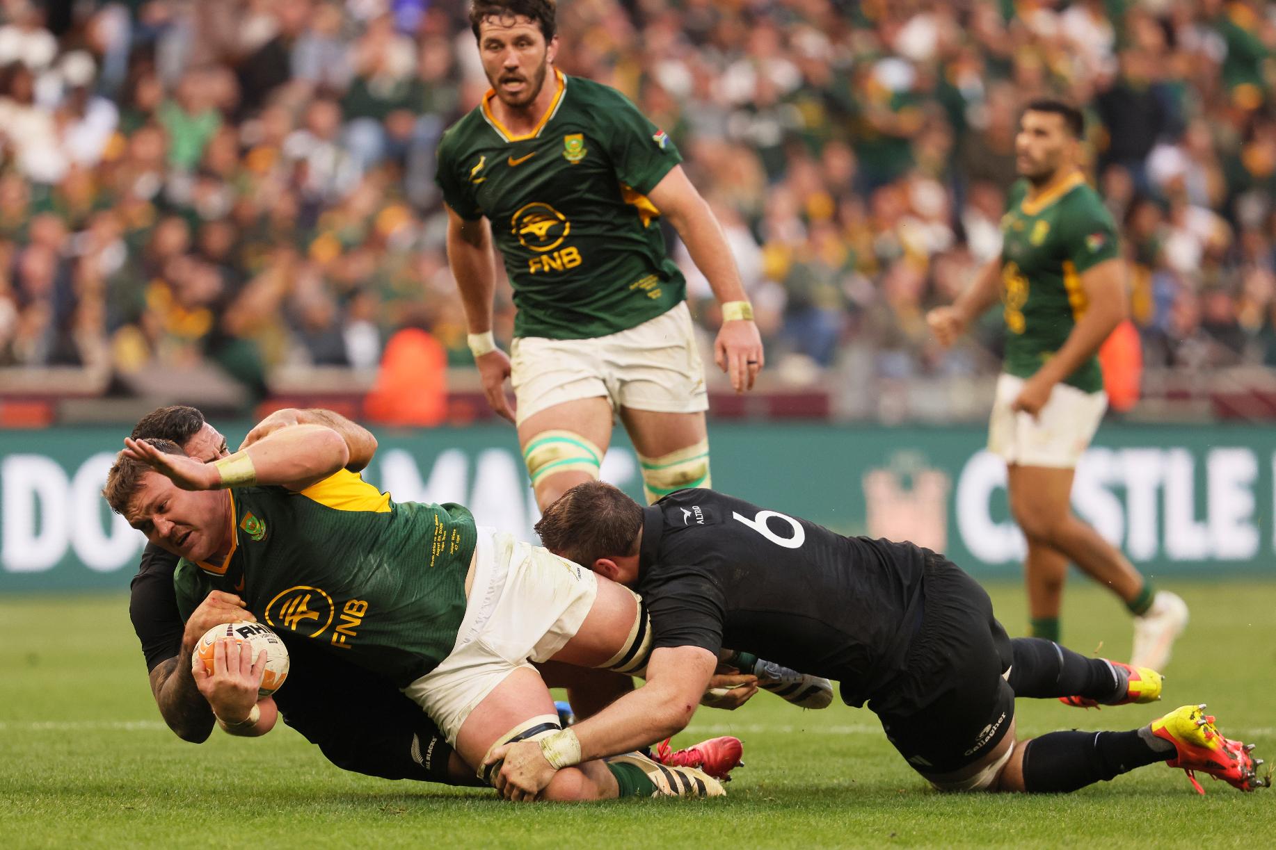 South Africa's Jasper Wiese, left, is being tackled down by New Zealand's Codie Taylor, back, and his teammate Simon Parker during a second Test rugby match between South Africa and New Zealand, in Cape Town, South Africa, Saturday, Aug. 29, 2026. (AP Photo/Halden Krog)