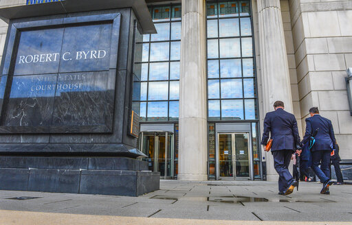 FILE - In this May 3, 2021, file photo, Huntington Mayor Steve Williams, left, and lawyer Rusty Webb enter the Robert C. Byrd United States Courthouse in Charleston, W.Va., for the start of a trial in an opioid lawsuit filed by Cabell County and the city of Huntington against major drug distributors.  Last July, a federal judge in West Virginia heard closing arguments in the first lawsuit to go to trial over the U.S. opioid addiction epidemic. With an avalanche of documents from the three-month trial, Judge David Faber didn’t indicate when he would make a ruling on the multibillion-dollar lawsuit filed by Cabell County and the city of Huntington against three major drug distributors, and his decision wasn't expected right away.(Kenny Kemp/Charleston Gazette-Mail via AP, File)