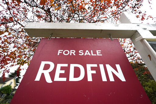 FILE - A Redfin "for sale" sign stands in front of a house on Oct. 28, 2020, in Seattle. The Seattle-based real estate brokerage says it will lay off 8% of its employees as the housing market cools off, Tuesday, June 14, 2022. (AP Photo/Elaine Thompson, File)