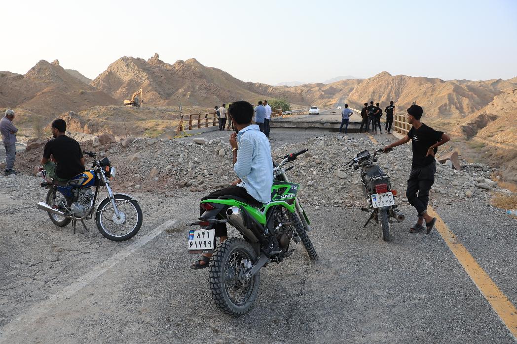 People stand on a bridge destroyed after a strike in Hormozgan province, southern Iran, Saturday, July 18, 2026. (Amirhosein Khorgooi/Iranian Students' News Agency via AP)