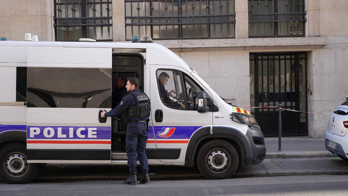 Police stand outside the Bank of America building in Paris, Saturday, March 28, 2026. (AP Photo/Nicolas Garriga)