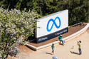 FILE - Visitors take photos at a sign outside Meta headquarters March 26, 2026, in Menlo Park, Calif. (AP Photo/Noah Berger, File)