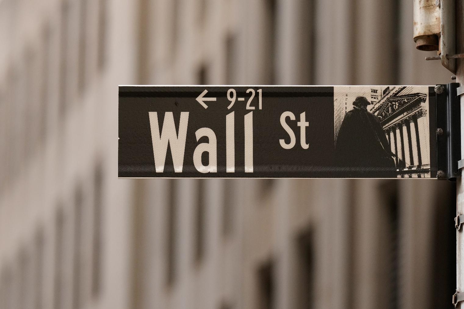 FILE - A Wall Street sign is seen outside of the New York Stock Exchange in New York, Monday, March 30, 2026. (AP Photo/Seth Wenig, File)