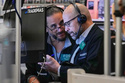 Options traders Chris Dattolo, left, and Steven Rodriguez work on the floor of the New York Stock Exchange, Friday, Feb. 20, 2026. (AP Photo/Richard Drew)