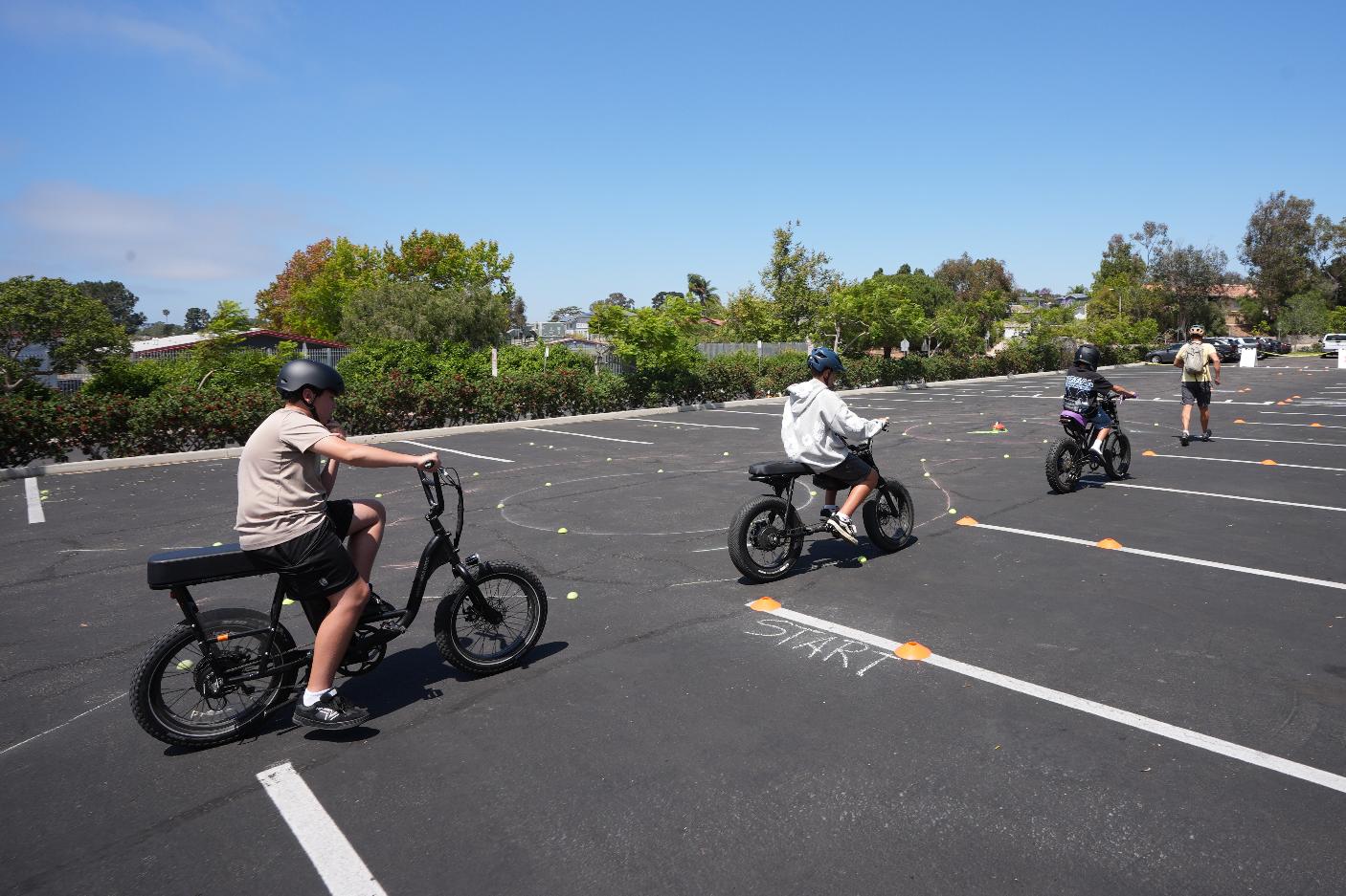 A group of kids ride e-bikes during an e-bike safety and training class Saturday, Aug. 8, 2026, in San Diego. (AP Photo/Gregory Bull)
