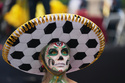 A dancer dressed as Catrina poses for photos as soccer fans stand along Reforma Avenue in Mexico City, Saturday, June 6, 2026 ahead of the FIFA World Cup. (AP Photo/Moises Castillo)