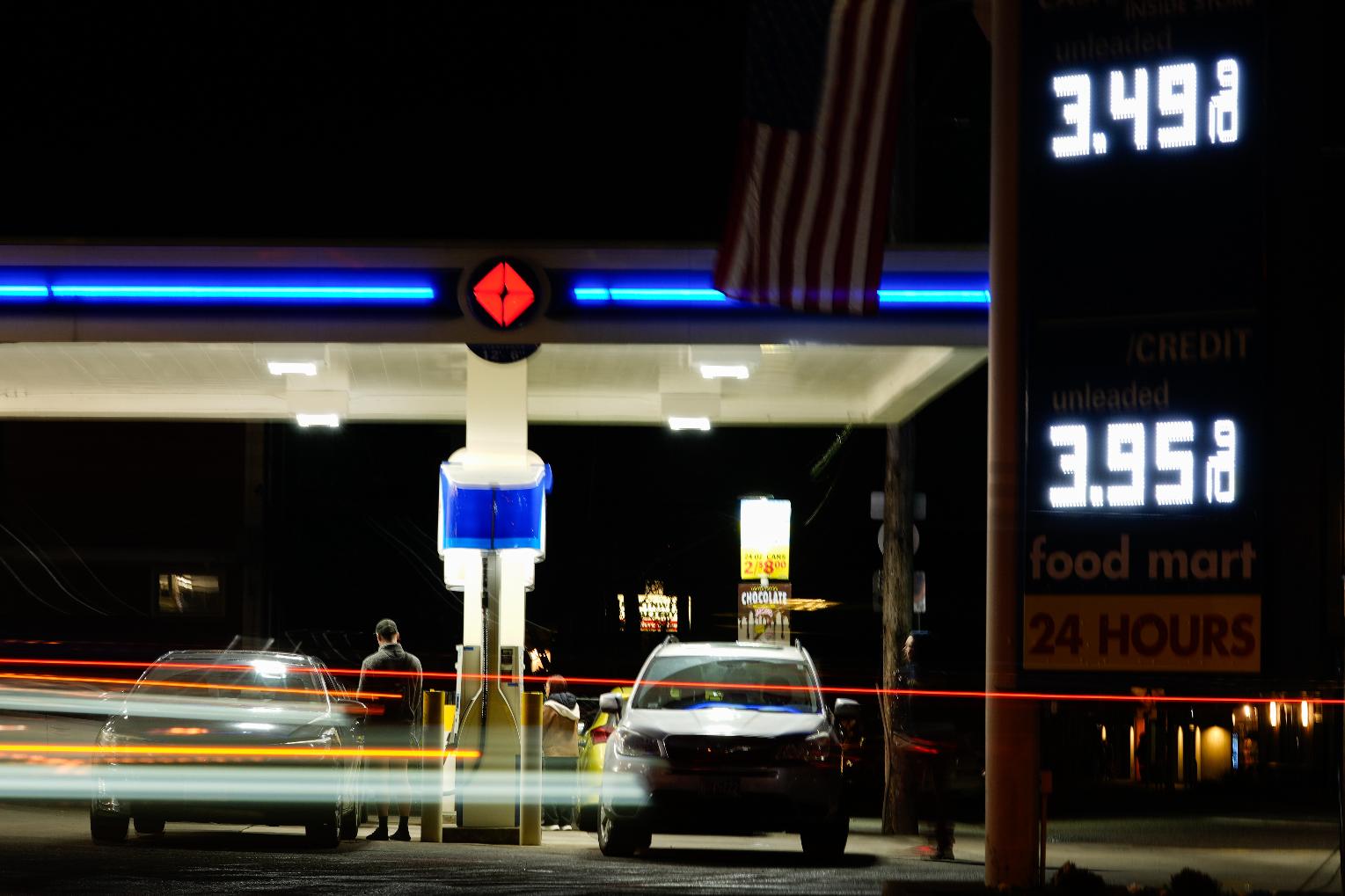 Vehicles drive past a gas station as a person puts gasoline in a vehicle on Sunday, March 8, 2026, in Portland, Ore. (AP Photo/Jenny Kane)