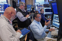 Robert Finnerty, Jr., foreground right, works with colleagues on the floor of the New York Stock Exchange, Thursday, May 7, 2026. (AP Photo/Richard Drew)
