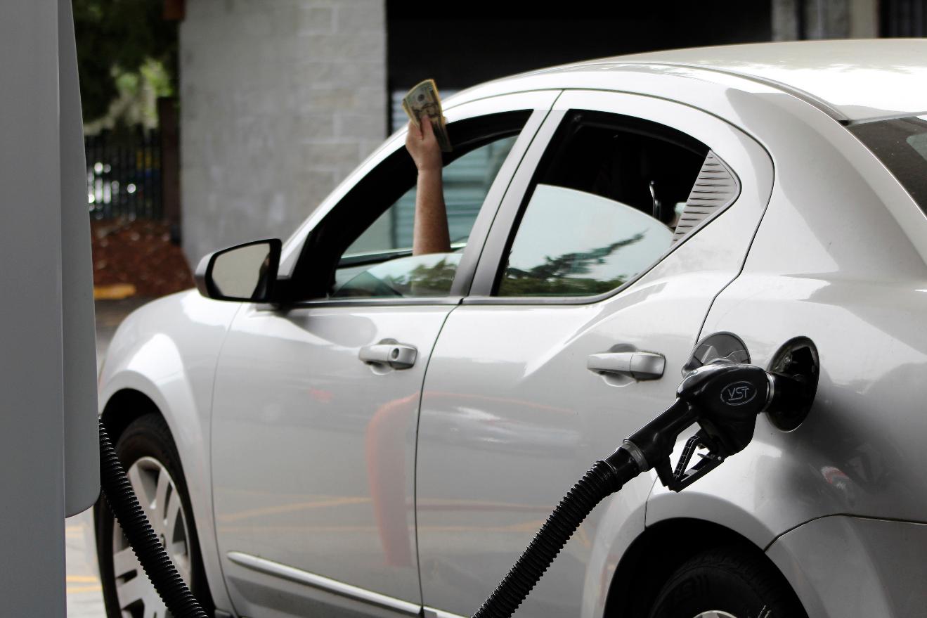A driver holds cash out of the window of their car while waiting to pay a gas station attendant to pump their gas, Friday, Aug. 4, 2023, in Portland, Ore. Oregon drivers can now pump their own gas for the first time since the 1950s, after Gov. Tina Kotek signed a bill allowing people across the state to choose between having an attendant pump their gas or doing it themselves. (AP Photo/Claire Rush)