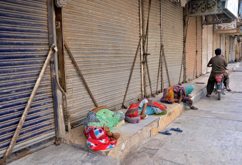 Pakistani women sleep on the ground as the shopkeepers closed their businesses during a strike against inflation in Hyderabad, Pakistan, Saturday, Sept. 2, 2023. Pakistani traders on Saturday went on strike against the soaring cost of living, including higher fuel and utility bills and record depreciation of the rupee against the dollar, which has led to widespread discontent among the public. (AP Photo/Pervez Masih)