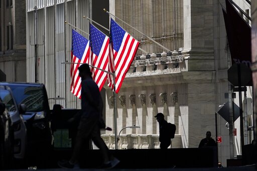 FILE - In this Oct. 14, 2020 file photo, pedestrians pass the New York Stock Exchange. Stocks are mixed on Wall Street, following gains in European markets, as more U.S. companies report encouraging results for the summer earnings period. (AP Photo/Frank Franklin II)