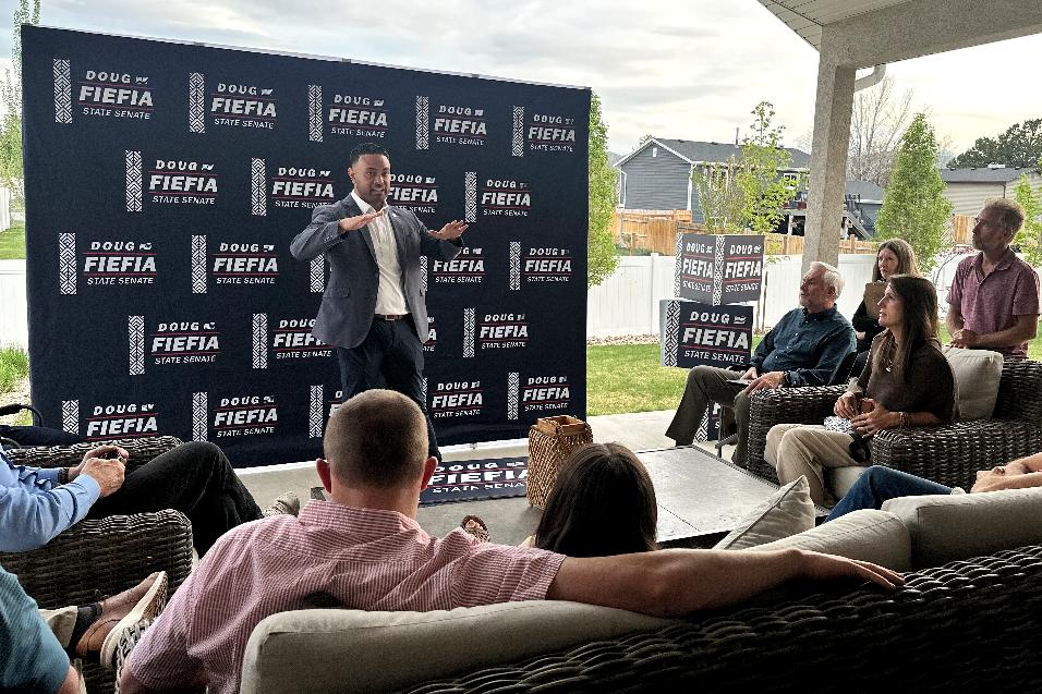 Utah State Rep. Doug Fiefia talks to Utah voters on the back deck of a house, Thursday, April 9, 2026, in Riverton, Utah. Fiefia, a Republican, has a background in technology and is running for the state senate with a pledge to tackle AI. (AP Photo/Nicholas Riccardi)