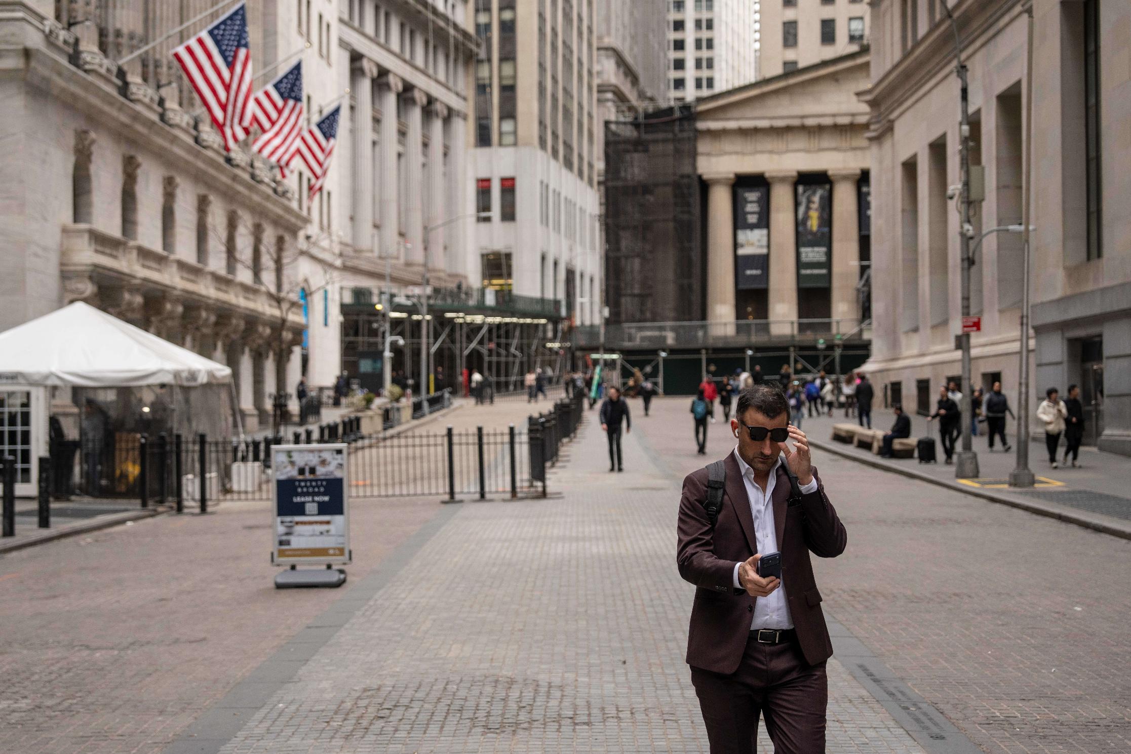 A person walks past the New York Stock Exchange, Friday, March 27, 2026, in New York. (AP Photo/Yuki Iwamura)