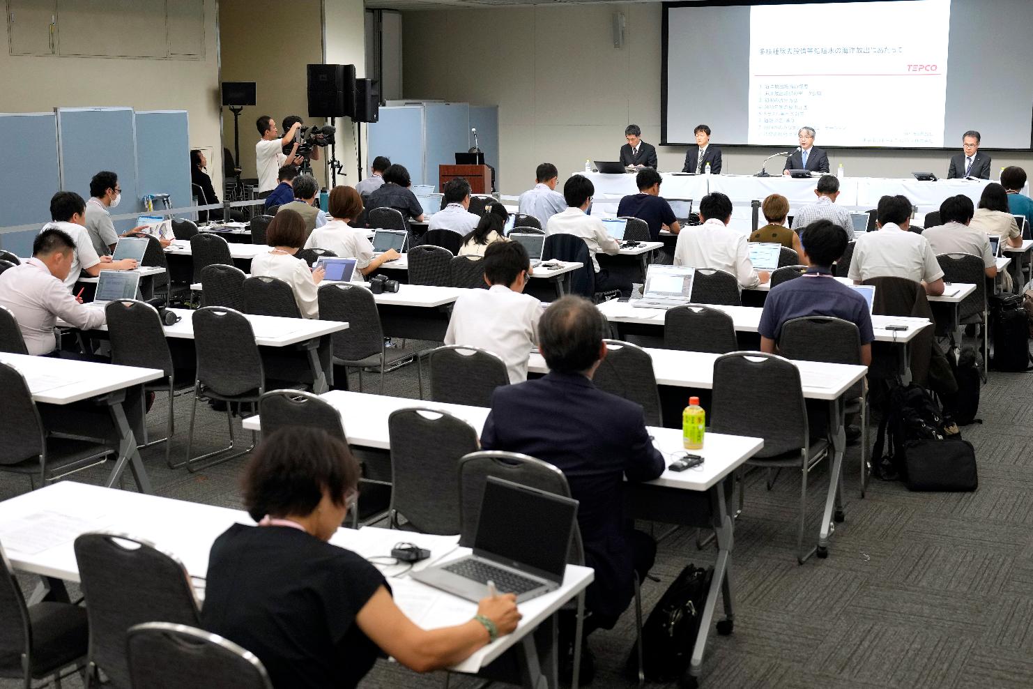 Junichi Matsumoto, second right in the background, the corporate officer in charge of treated water management for Tokyo Electric Power Co. (TEPCO) Holdings, which operates the Fukushima No. 1 nuclear power plant, speaks during a press conference at TEPCO headquarter building Tuesday, Aug. 22, 2023, in Tokyo. (AP Photo/Eugene Hoshiko)