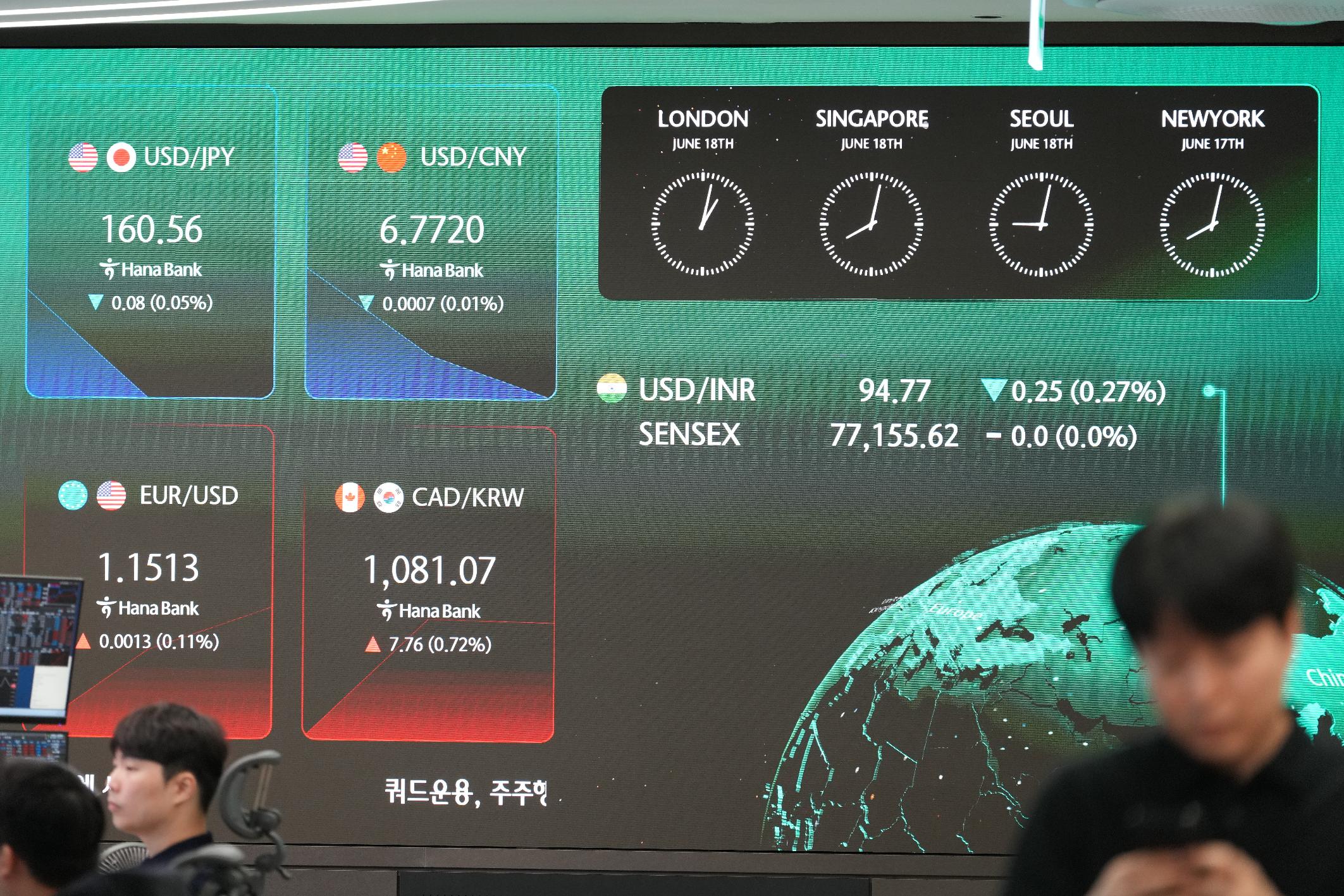 A dealer walks past near the screens showing the foreign exchange rates at a dealing room of Hana Bank in Seoul, South Korea, Thursday, June 18, 2026. (AP Photo/Lee Jin-man)