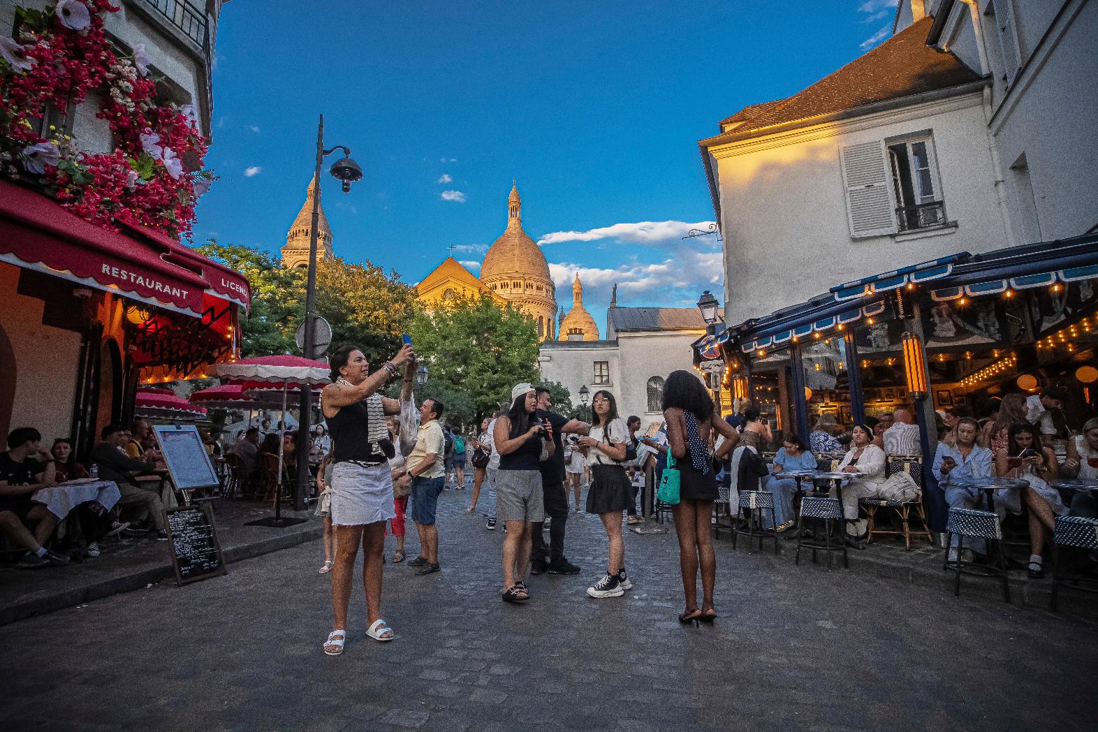 Tourists stroll in the Montmartre district in Paris, France, Monday, Aug. 4, 2025. (AP Photo/Aurelien Morissard)