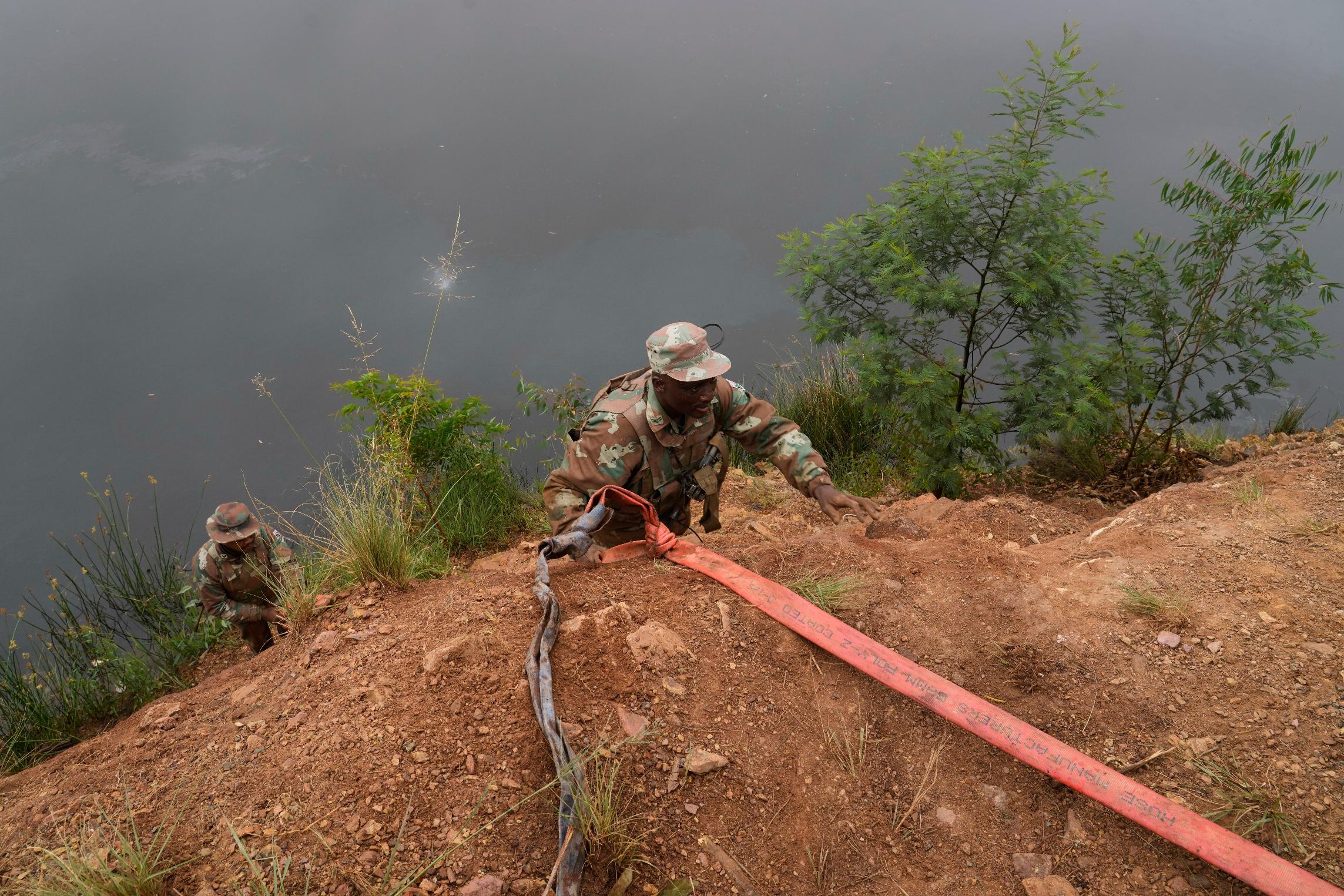 South African National Defense Force soldiers recover a generator left behind by illegal miners, during a patrol in Randfontein, in Johannesburg, South Africa, Thursday, March 12, 2026. (AP Photo/Themba Hadebe)