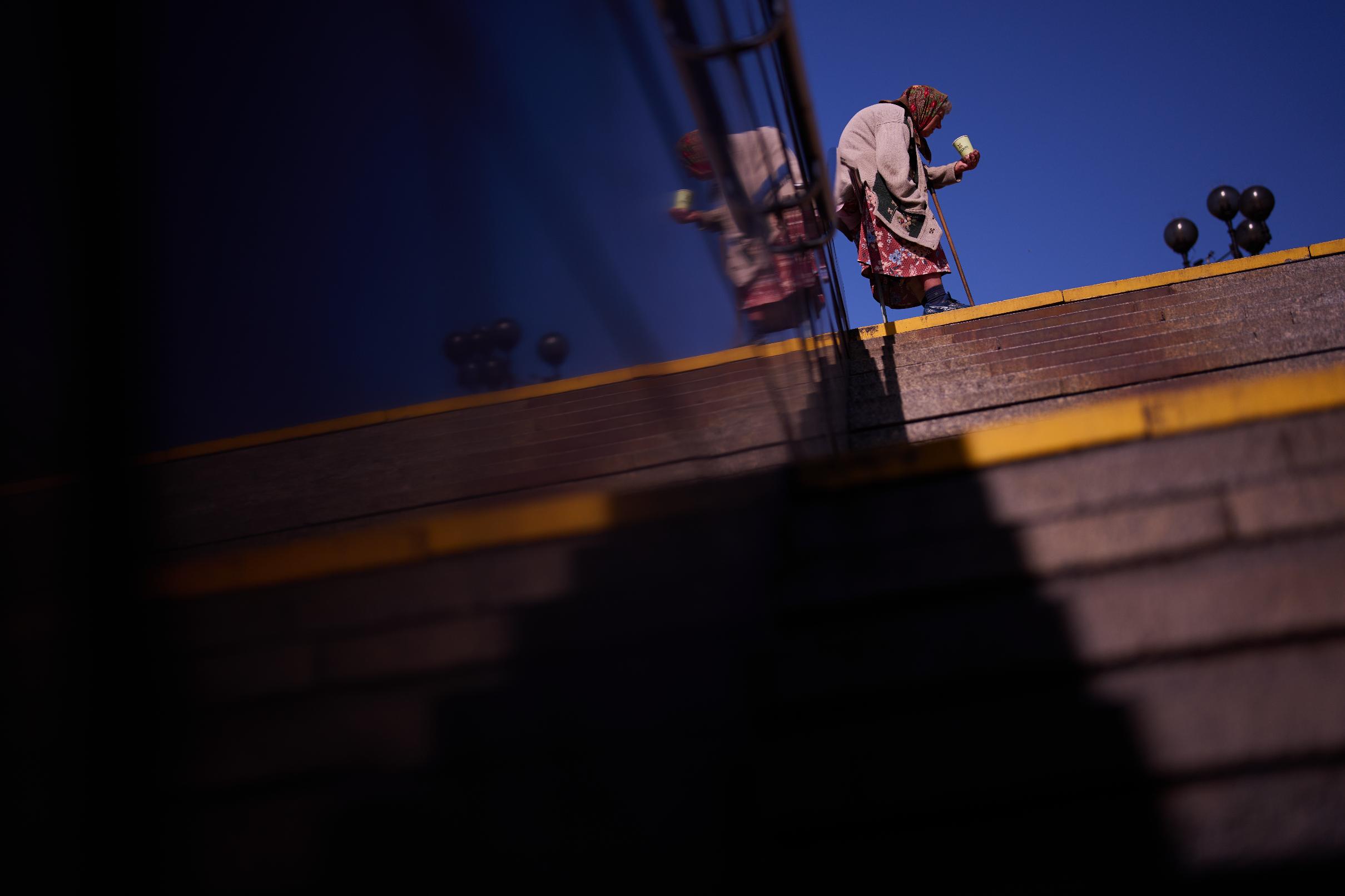 A woman begs for money at Maidan metro entrance during an air raid alarm in central Kyiv, Ukraine, Thursday, Aug. 27, 2026. (AP Photo/Francisco Seco)
