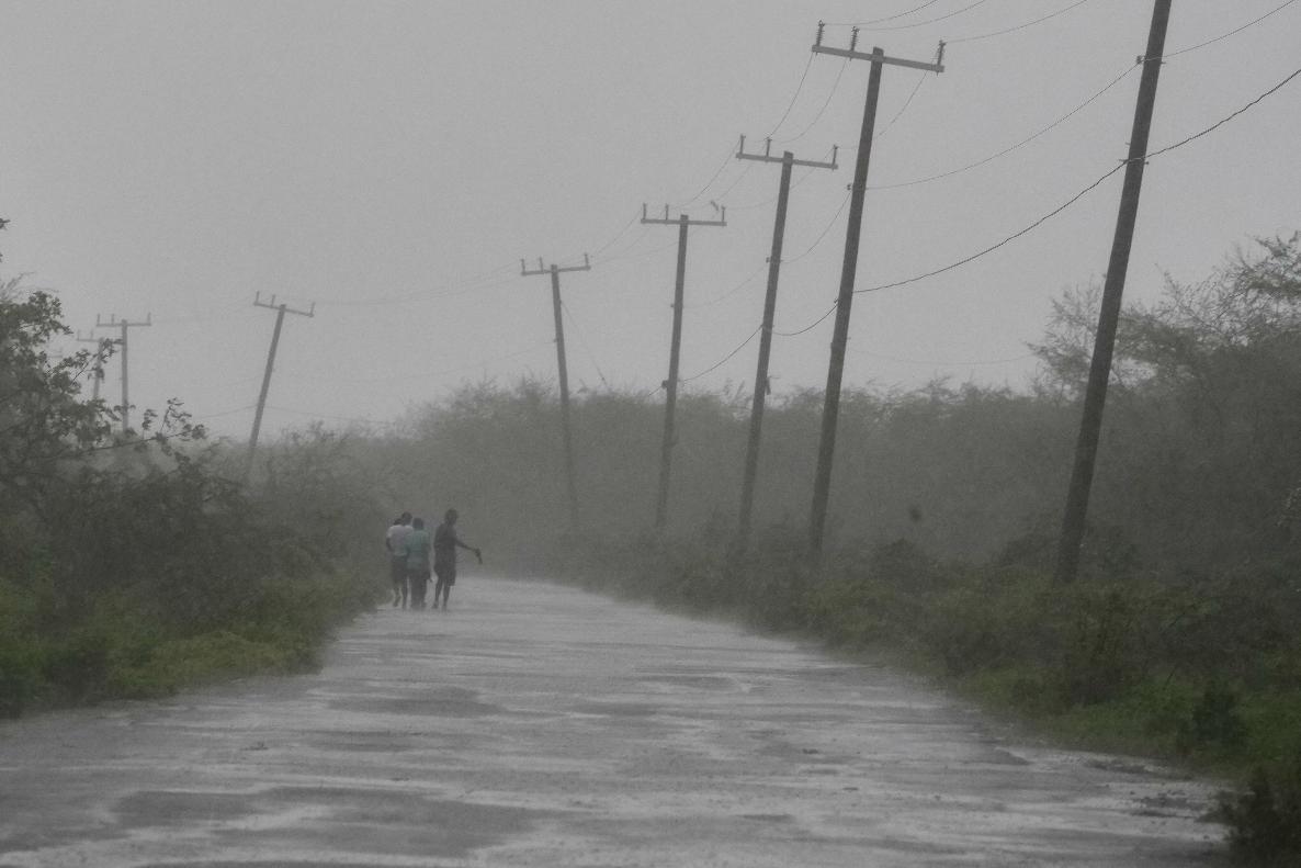 People walk along a road during the passing of Hurricane Melissa in Rocky Point, Jamaica, Tuesday, Oct. 28, 2025. (AP Photo/Matias Delacroix)