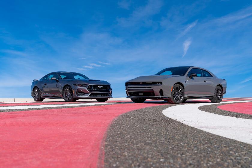 This photo provided by Edmunds shows the newest Dodge Charger and Ford Mustang, historic rivals. (Courtesy of Edmunds via AP)