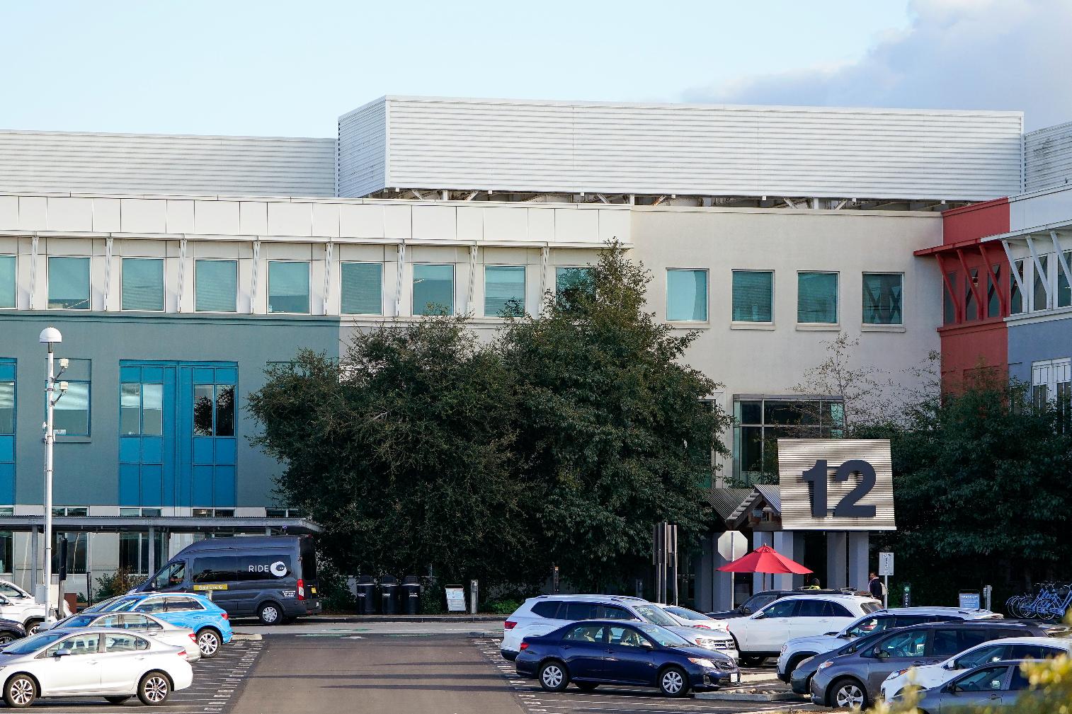 Cars can be seen parked in a parking lot at Meta headquarters in Menlo Park, Calif., Wednesday, Nov. 9, 2022. Meta, which is the parent company to Facebook, is laying off 11,000 people, about 13% of its workforce, as it contends with faltering revenue and broader tech industry woes, CEO Mark Zuckerberg said in a letter to employees Wednesday. (AP Photo/Godofredo A. Vásquez)