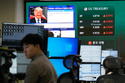 U.S. President Donald Trump is seen on a screen as traders work at the foreign exchange dealing room of the Hana Bank headquarters in Seoul, South Korea, Monday, April 6, 2026. (AP Photo/Ahn Young-joon)