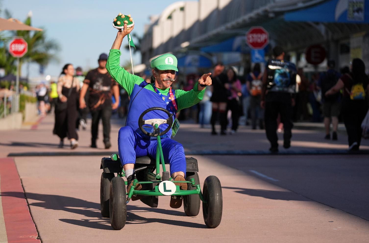 Matt Armstrong, of San Diego, dressed as the character Luigi from the Mario Kart video game series, greets attendees during preview night for Comic-Con International on Wednesday, July 22, 2026, in San Diego. (AP Photo/Chris Pizzello)