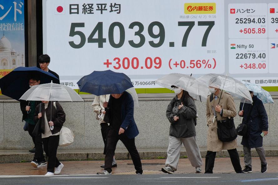 Perople walk in front of an electronic stock board showing Japan's Nikkei index at a securities firm Thursday, April 2, 2026, in Tokyo. (AP Photo/Eugene Hoshiko)