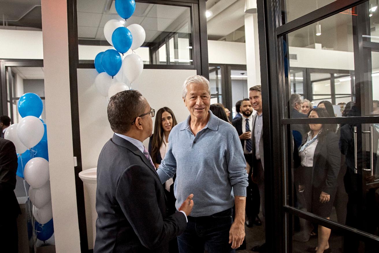 FILE - Jamie Dimon, CEO and chairman of JPMorgan Chase, center right, talks with an attendee during the community branch opening in the Bronx borough of New York, April 26, 2024. (AP Photo/Andres Kudacki, File)