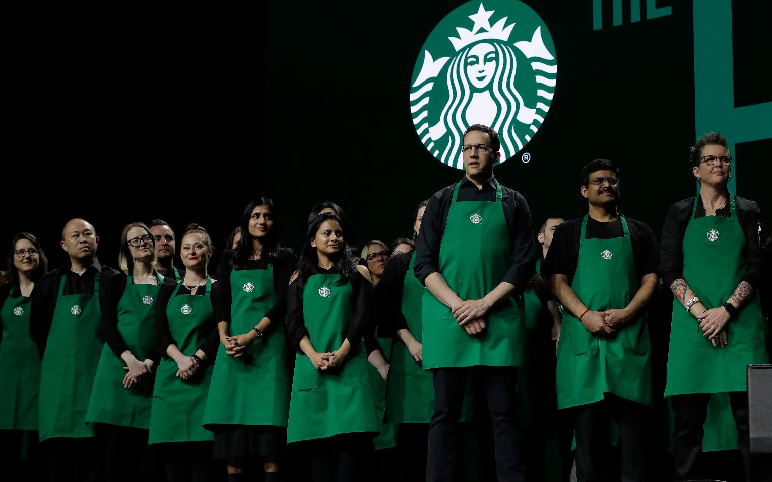 FILE - Starbucks baristas stand on stage, March 20, 2019, during an annual shareholders meeting in Seattle. (AP Photo/Ted S. Warren, file)