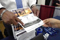 Curtis McCray, a Mississippi Department of Corrections recruiter, left, points out a positive testimonial to a job applicant during the Lee County Area Job Fair in Tupelo, Miss., Tuesday, Oct. 12, 2021. Employers representing a variety of manufacturing, production, service industry, medical and clerical companies attended the day long affair with an eye towards recruitment, hiring, training and retention. (AP Photo/Rogelio V. Solis)