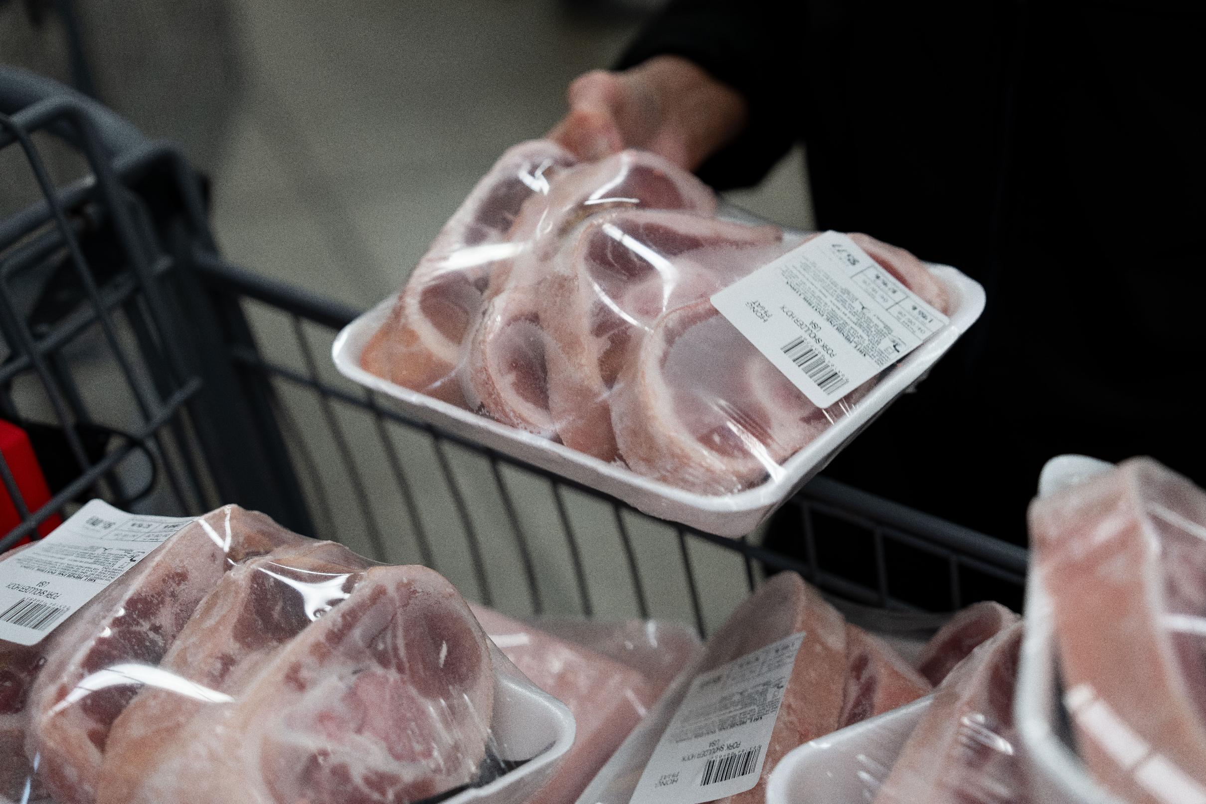 A customer picks up packaged pork at a grocery store in Portland, Ore., Wednesday, April 8, 2026. (AP Photo/Jenny Kane)