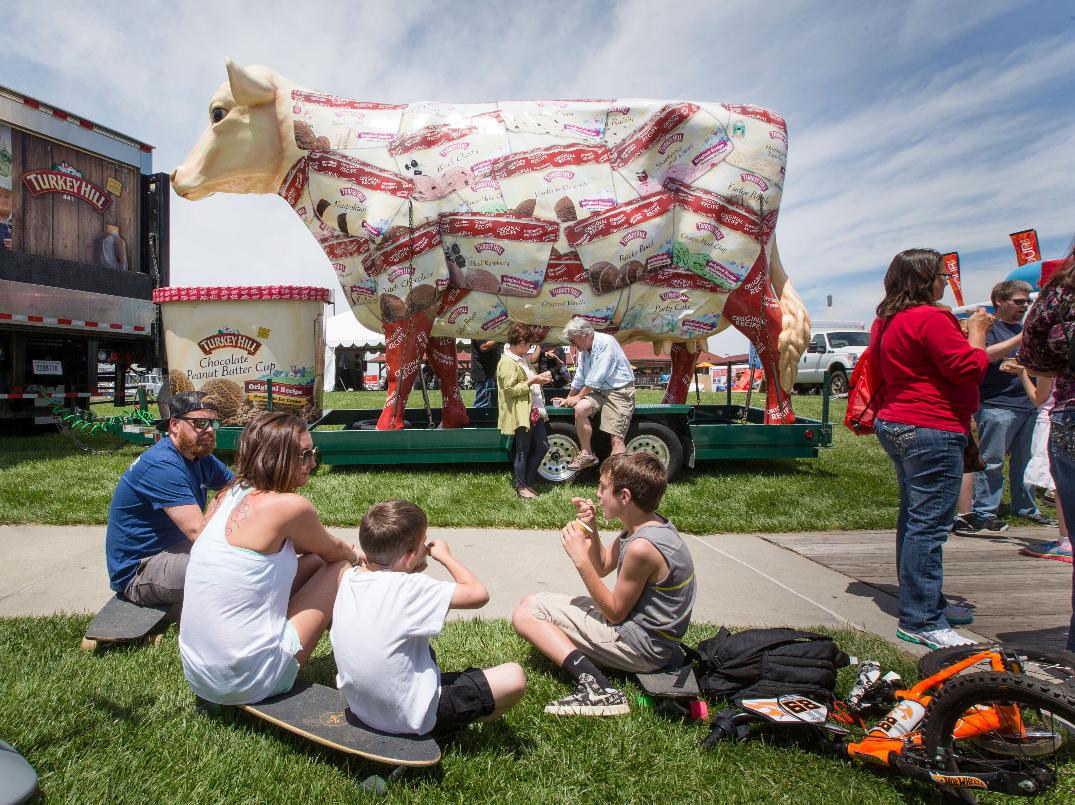 FILE - The giant Turkey Hill Cow looms over festival goers sampling ice cream at Taste of Omaha on May 31, 2015, in Omaha, Neb. (Kent Sievers/Omaha World-Herald via AP, FILE)