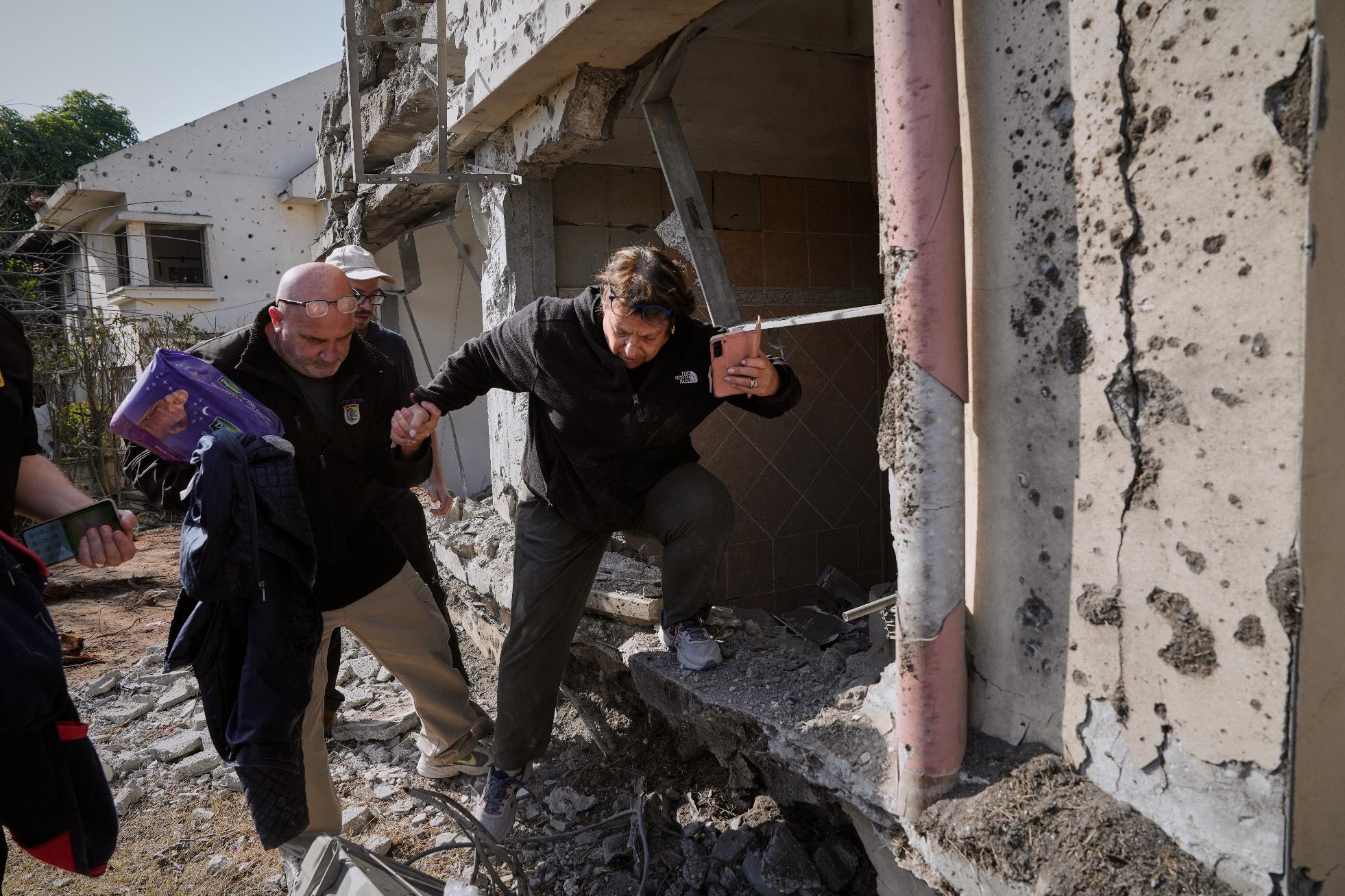 A woman gathers belongings from her family's home after it was damaged by a projectile launched from Lebanon, in Haniel, central Israel, Thursday, March 12, 2026. (AP Photo/Baz Ratner)