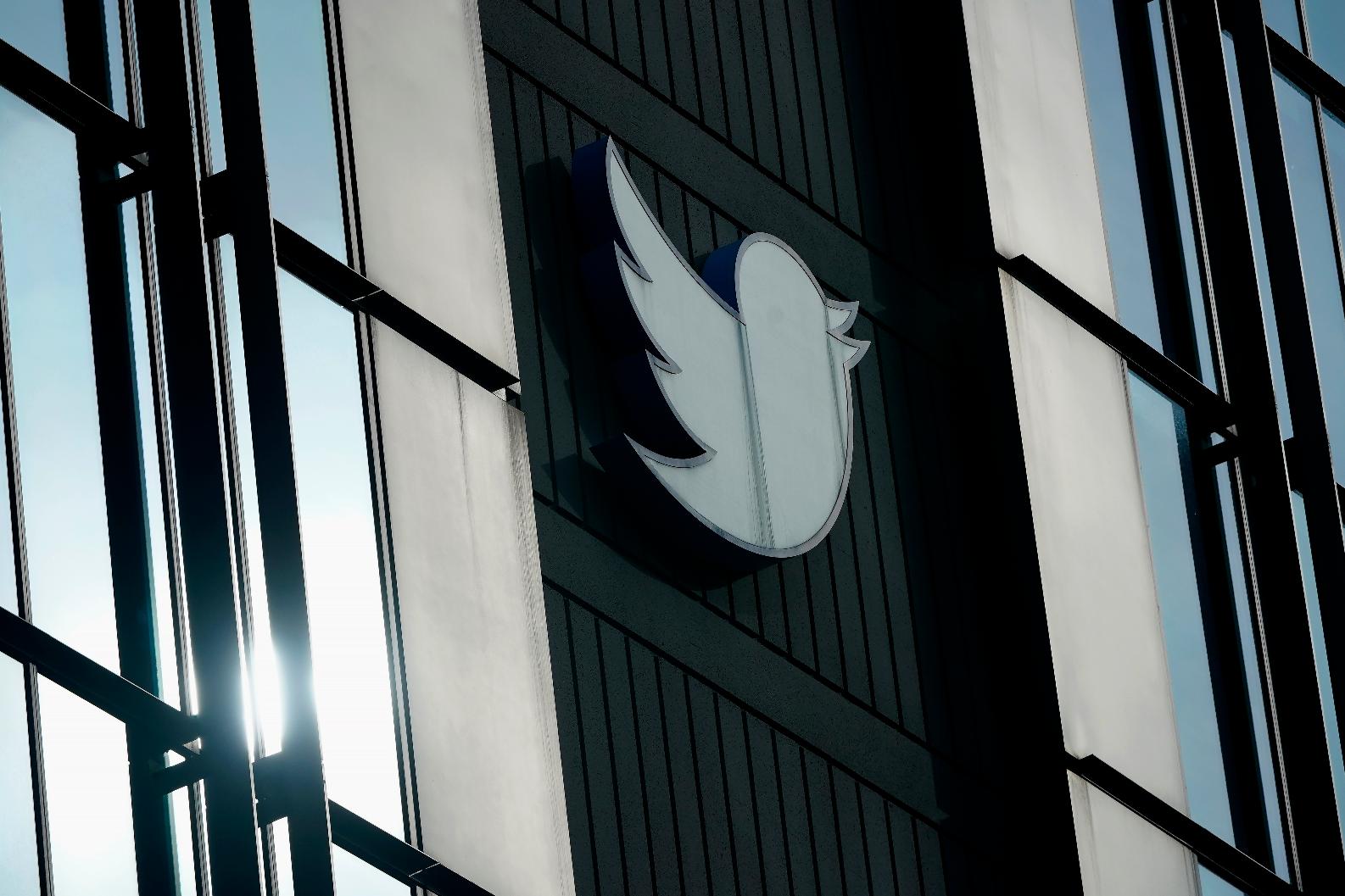 FILE - A Twitter logo hangs outside the company's offices in San Francisco, on Dec. 19, 2022. The company is auctioning off memorabilia, fancy office furniture and professional kitchen equipment from its San Francisco offices, where large spaces now sit empty and free meals are a relic of the past.Even when all added up, the money raised from the auction, which closes Wednesday, Jan. 18, 2023, is unlikely to make a dent in Twitter's financial obligations. (AP Photo/Jeff Chiu, File)