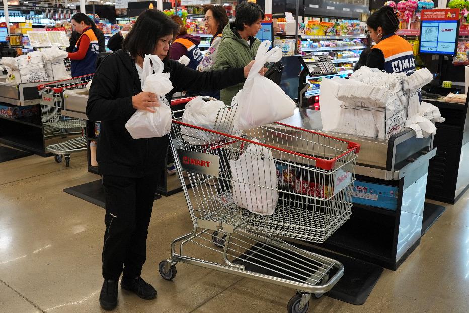 A shopper checks out at a cash register in a grocery store, in Schaumburg, Ill., Thursday, April 2, 2026. (AP Photo/Nam Y. Huh)